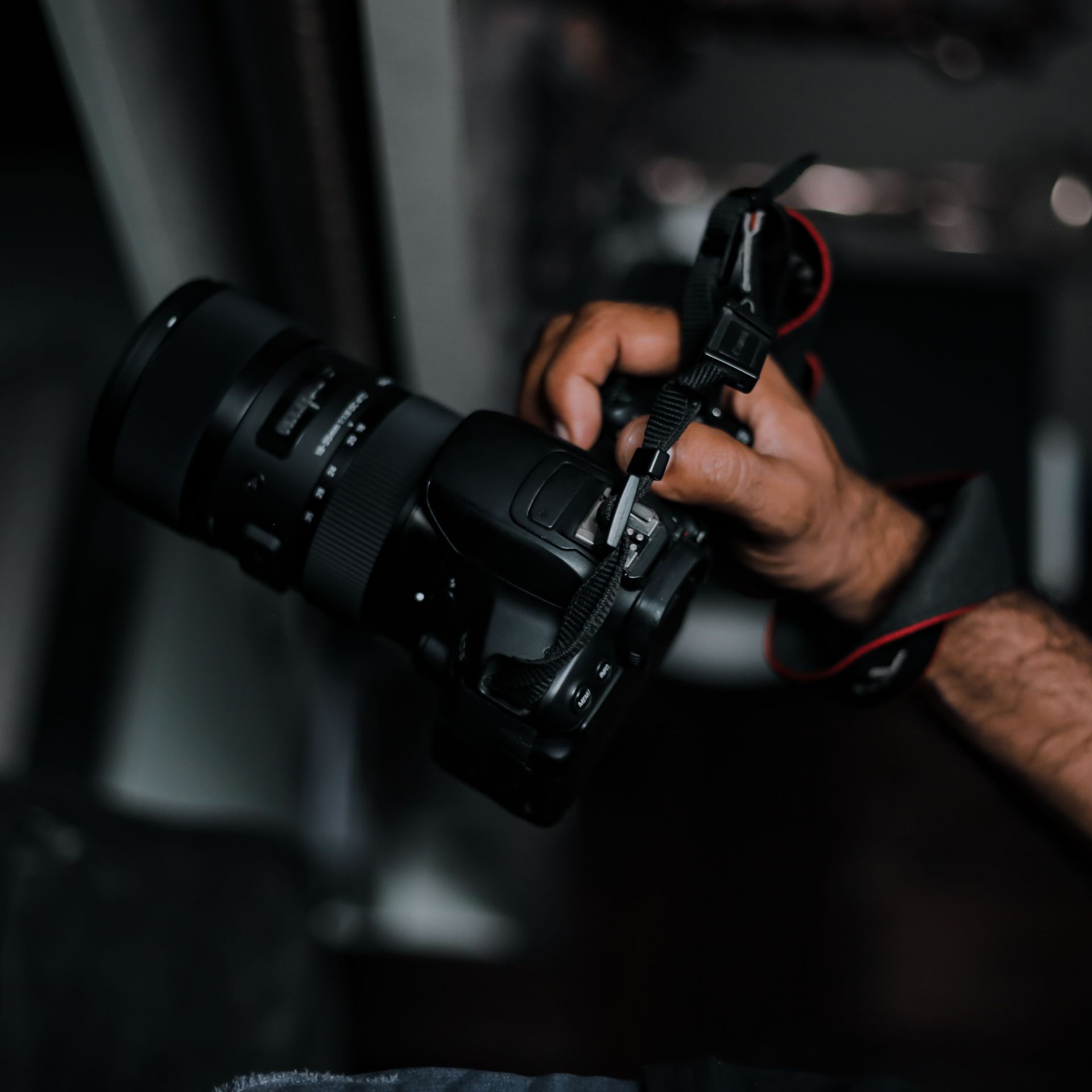 A photographer's hand holding a DSLR camera, showcasing photography in action.