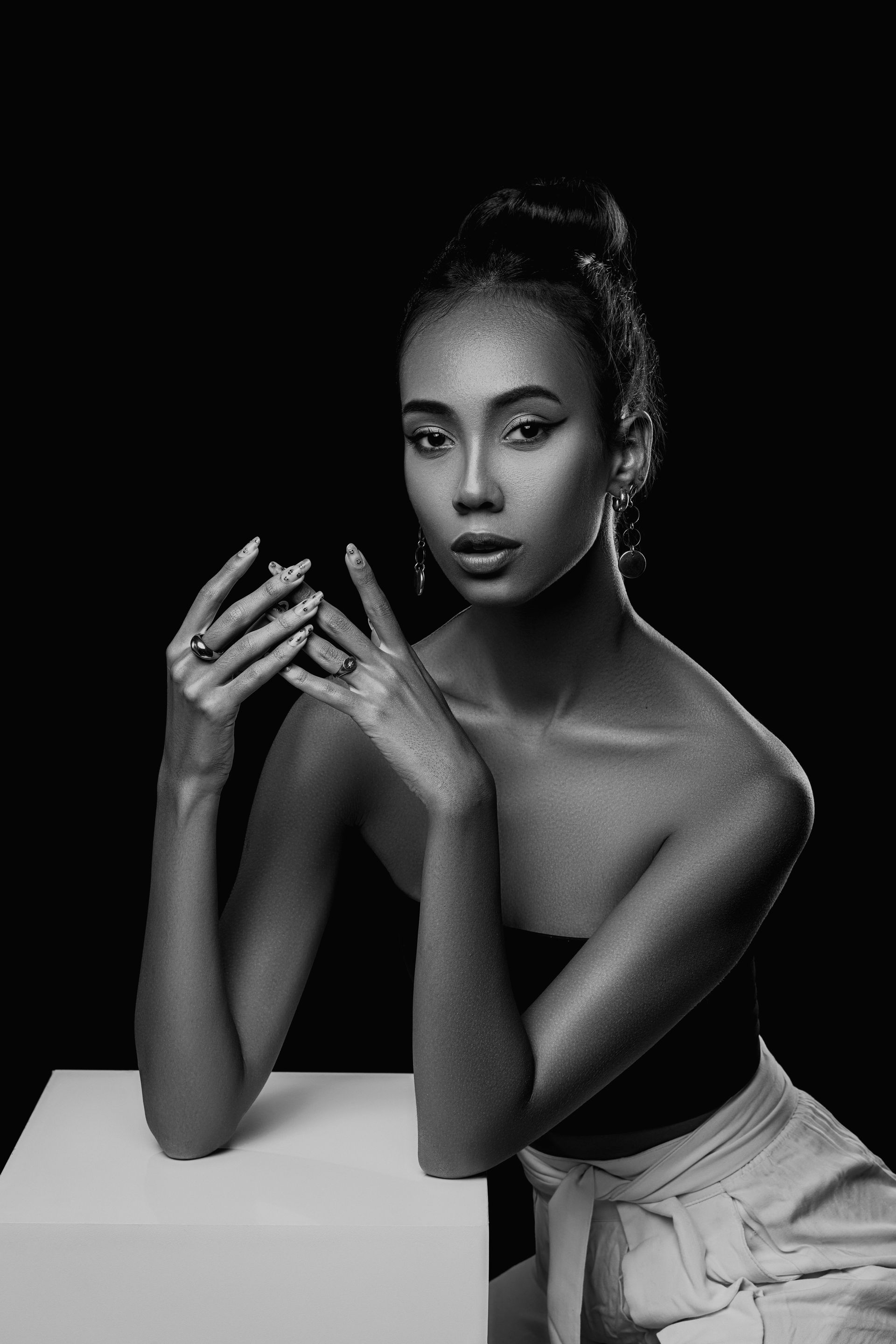 Striking black and white portrait of a woman in a studio setting.